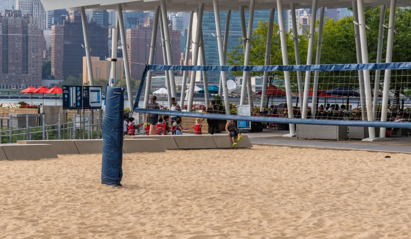 Beach volleyball by the ferry with the Manhattan skyline in the background.