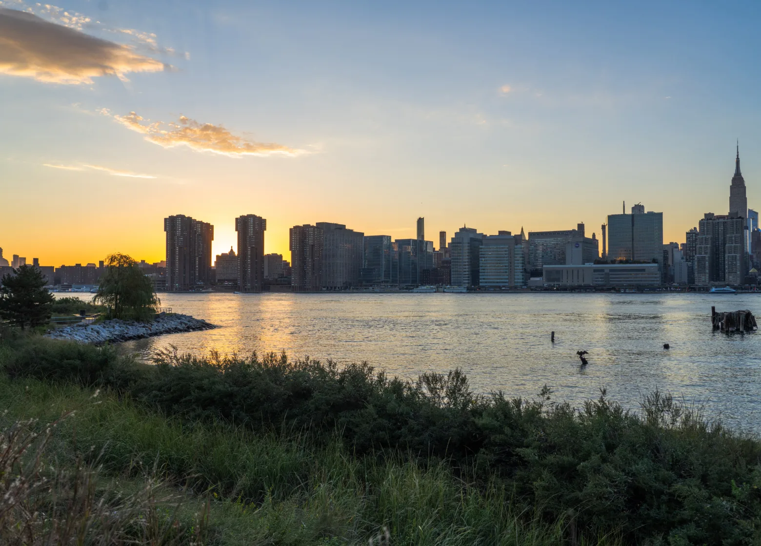 View across the east river of the midtown skyline at sunset from Hunter's Point South Park.